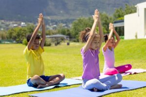 Enfant assis en posture de yoga sur un tapis dans une salle claire