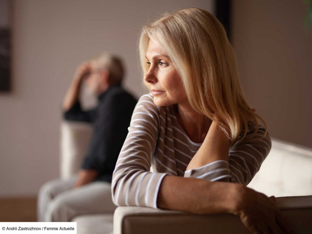Femme assise à distance de son compagnon sur un canapé, illustration du manque d'affection dans le couple