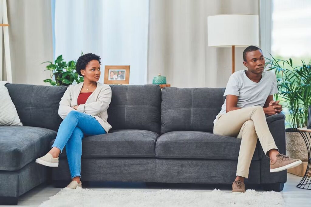 Femme lassée écoutant les remarques de son mari lors d'une discussion tendue à la maison